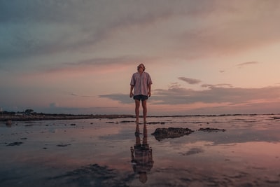 夕阳下站在沙滩上的白衣女子